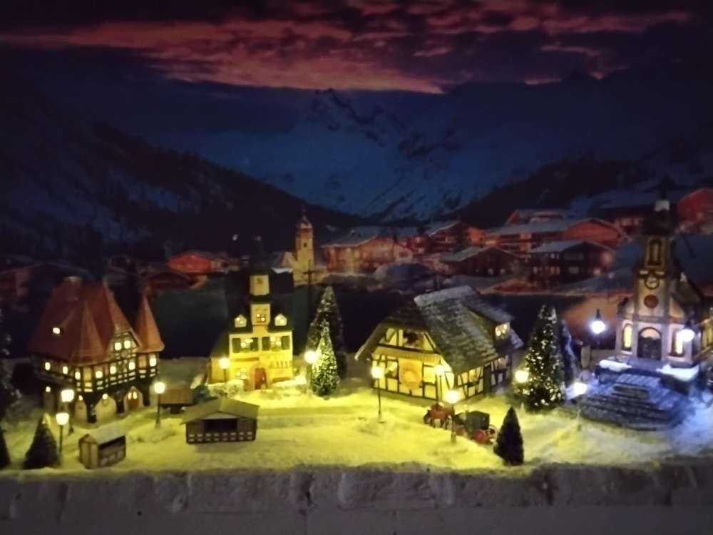 Avondlicht over bergdorp in de sneeuw