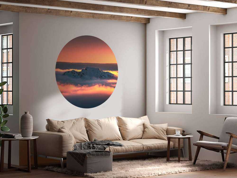 Besneeuwde bergtop in wolkenzee