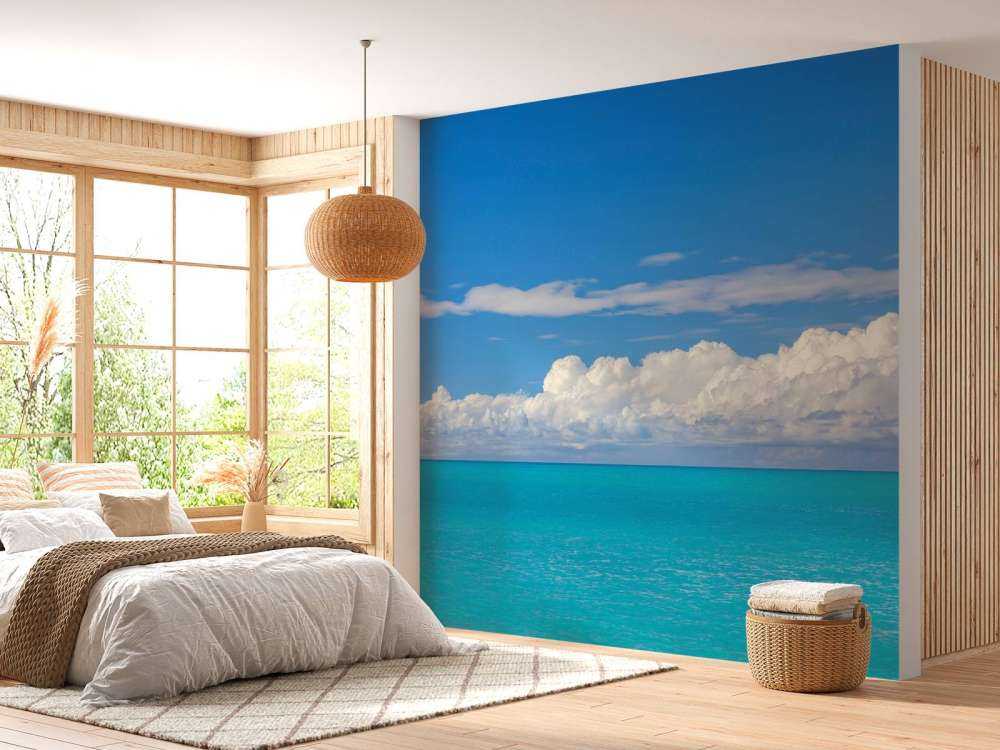 Panoramic view of a blue seascape with sailboat and cloudy sky