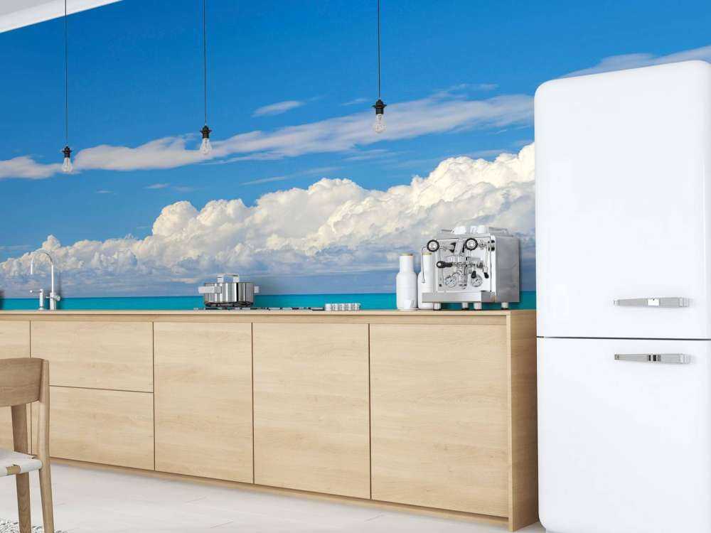 Panoramic view of a blue seascape with sailboat and cloudy sky
