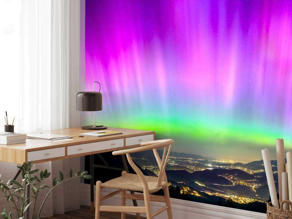 Noorderlicht boven verlichte bergstad