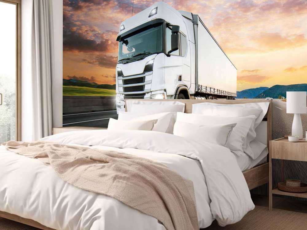 Witte vrachtwagen op de snelweg bij zonsondergang