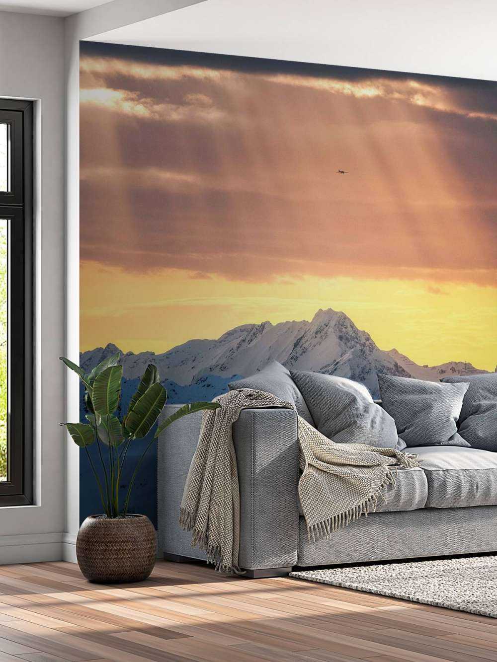 Zonnestralen boven besneeuwde bergtoppen