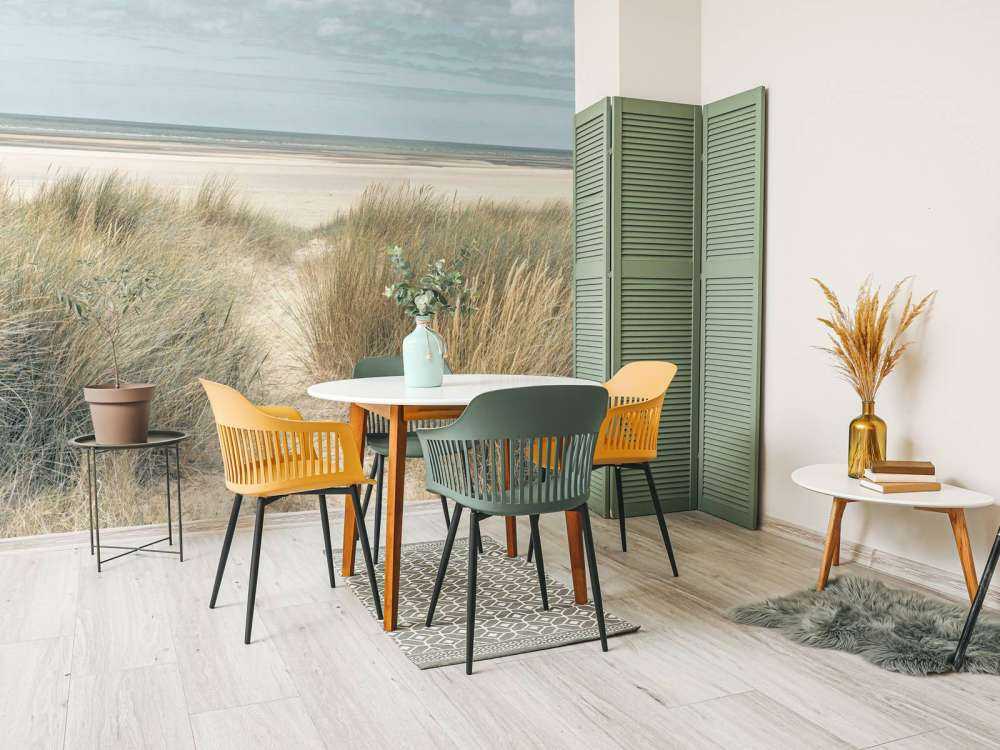 Grassy sand dunes on the sea coast under blue sky