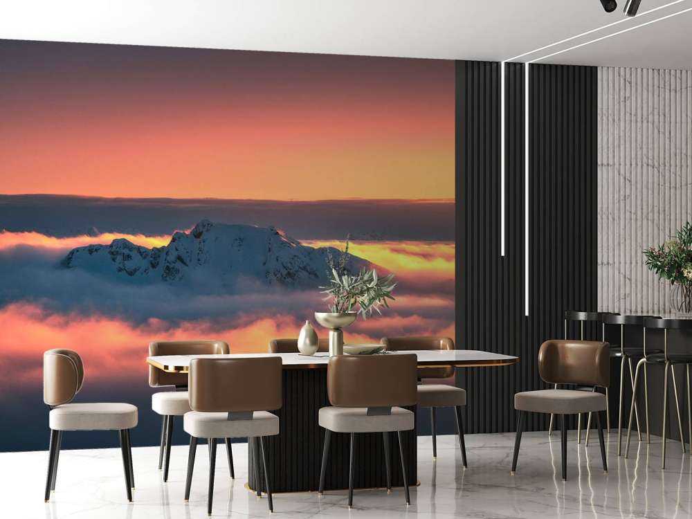 Besneeuwde bergtop in wolkenzee