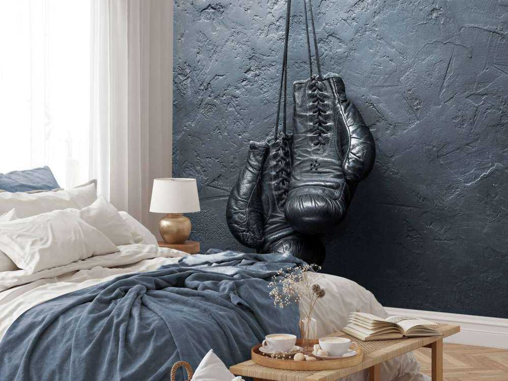 Old school zwarte bokshandschoenen aan een donkere muur