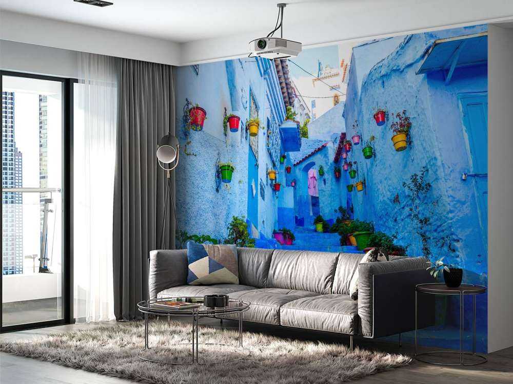 Blauwe straat met kleurrijke bloemenemmers in Marokko