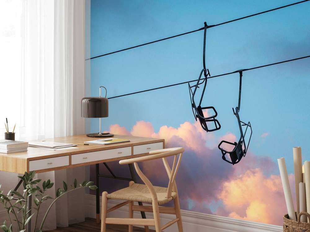 Stoeltjeslift boven roze avondwolken