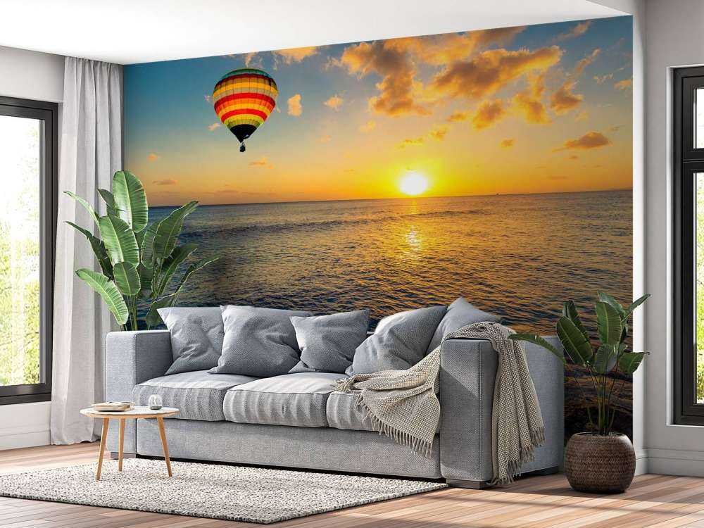 Luchtballon boven zee bij zonsondergang