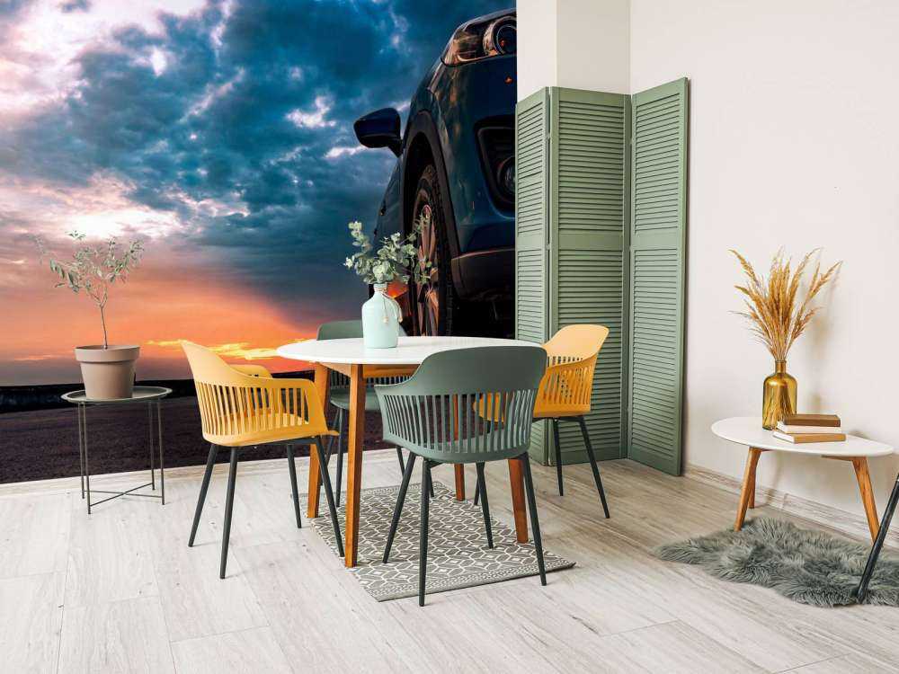 Een blauwe SUV met een unieke lucht op de achtergrond