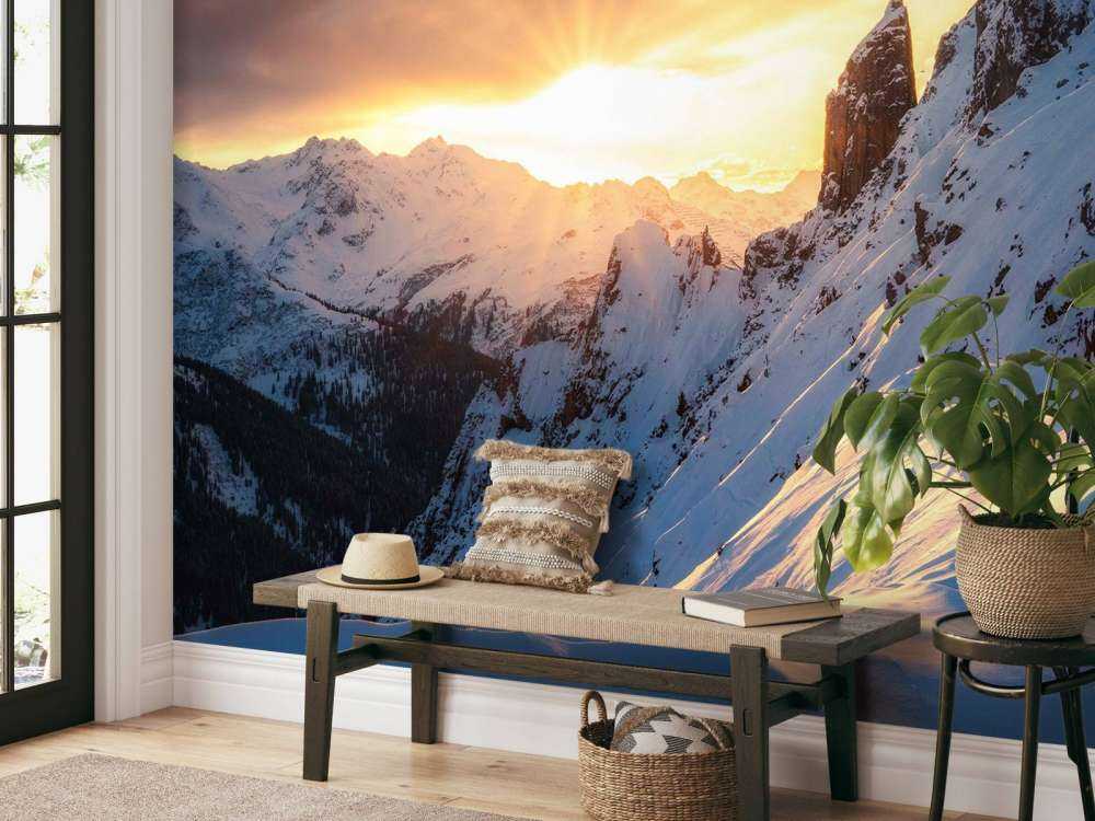 Avondzon achter besneeuwde bergtoppen