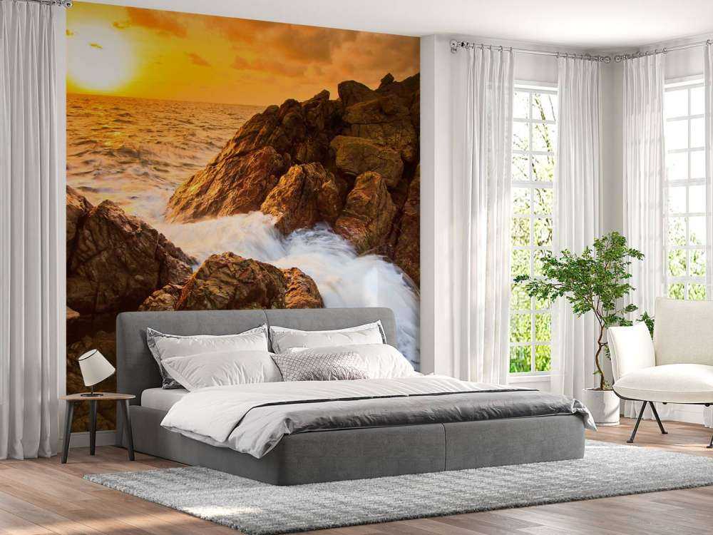 Zee met rotsen bij zonsondergang