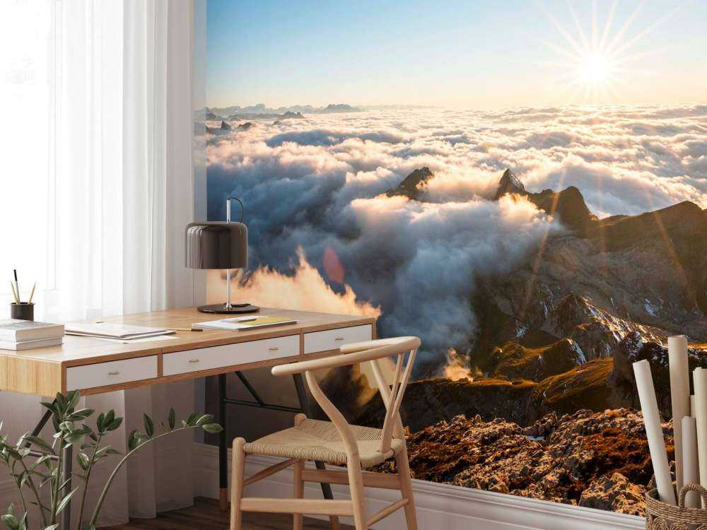 Zon boven wolkendek en bergtoppen