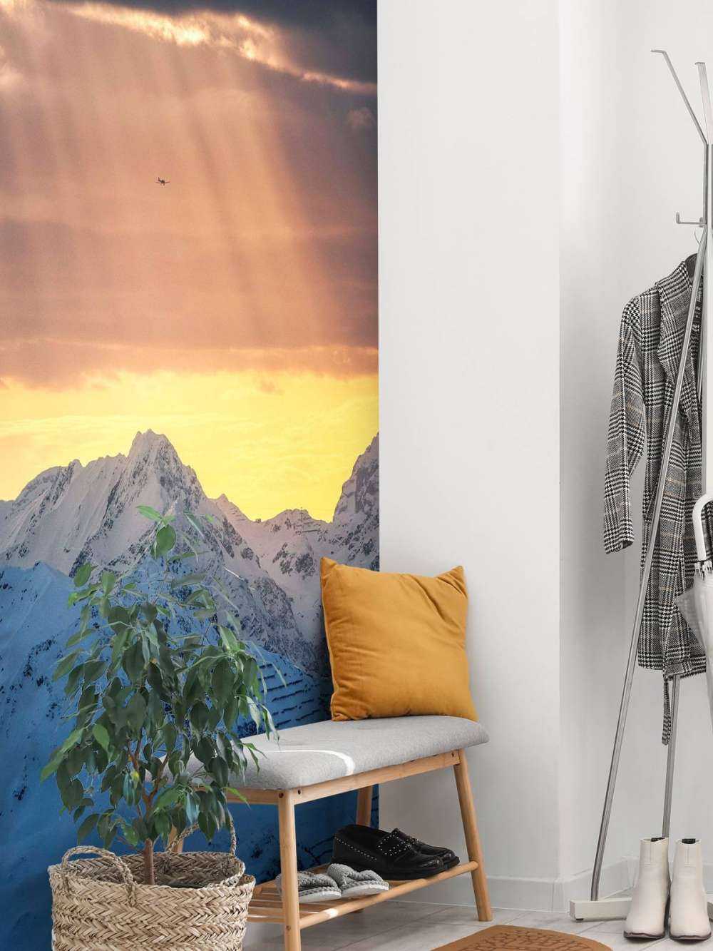 Zonnestralen boven besneeuwde bergtoppen