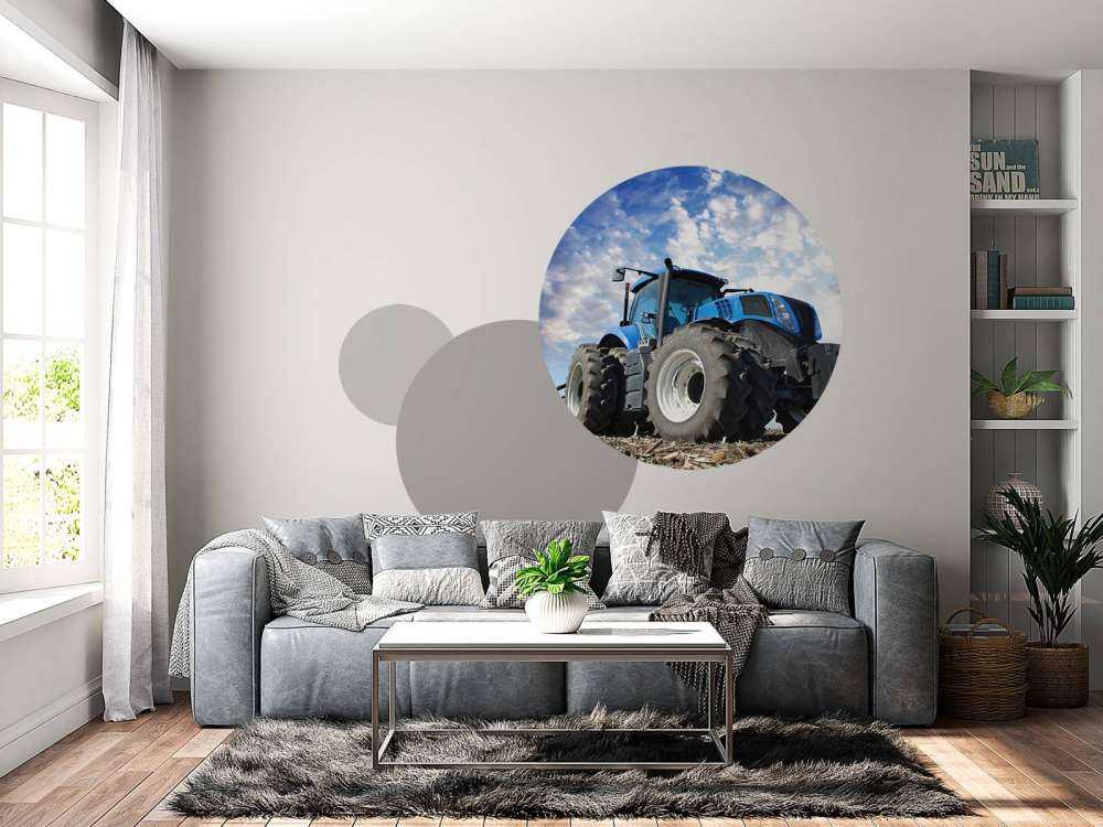 Grote blauwe tractor onder een bewolkte hemel