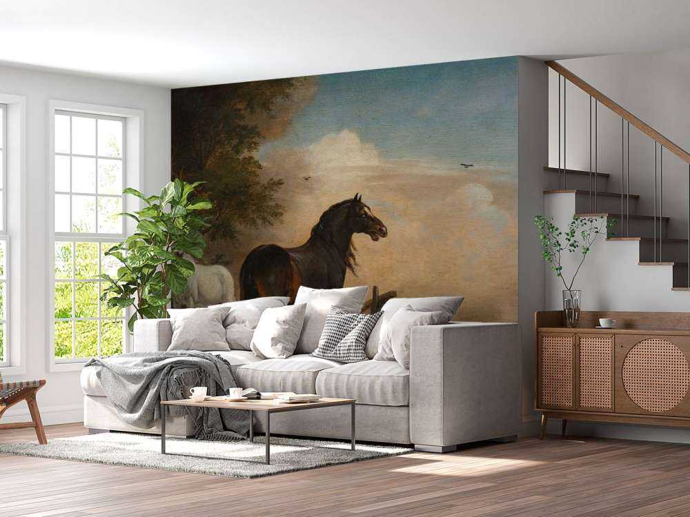 Twee paarden in de weide bij een hek