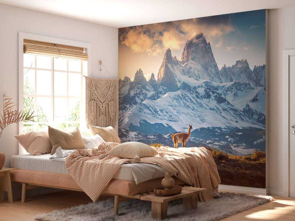 Guanaco bij besneeuwde bergtoppen