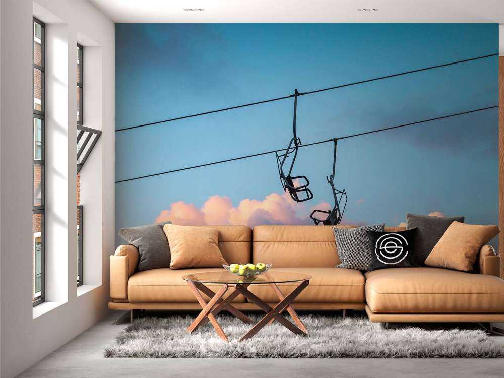 Stoeltjeslift boven roze avondwolken