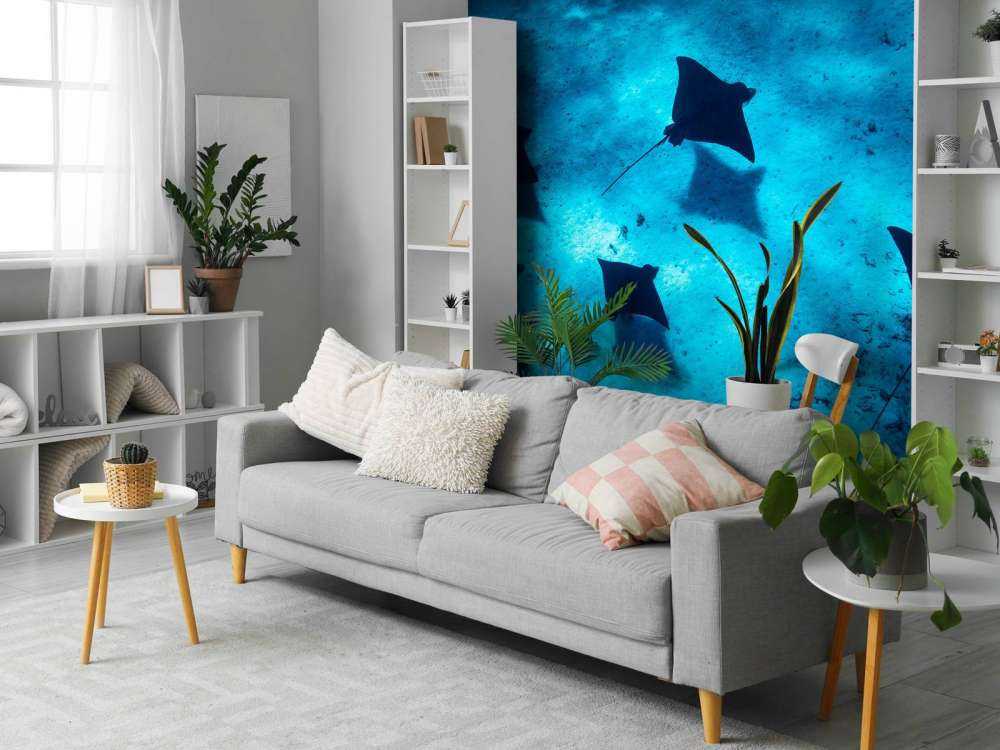 Mantaroggen zwevend door diepblauw rif