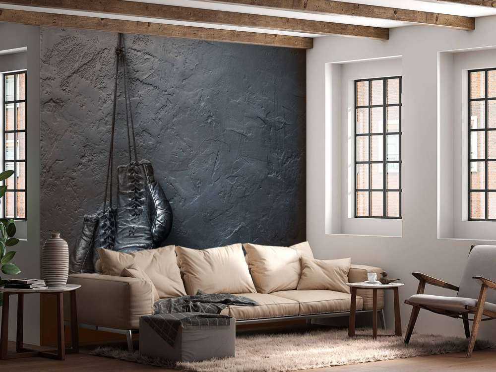 Old school zwarte bokshandschoenen aan een donkere muur