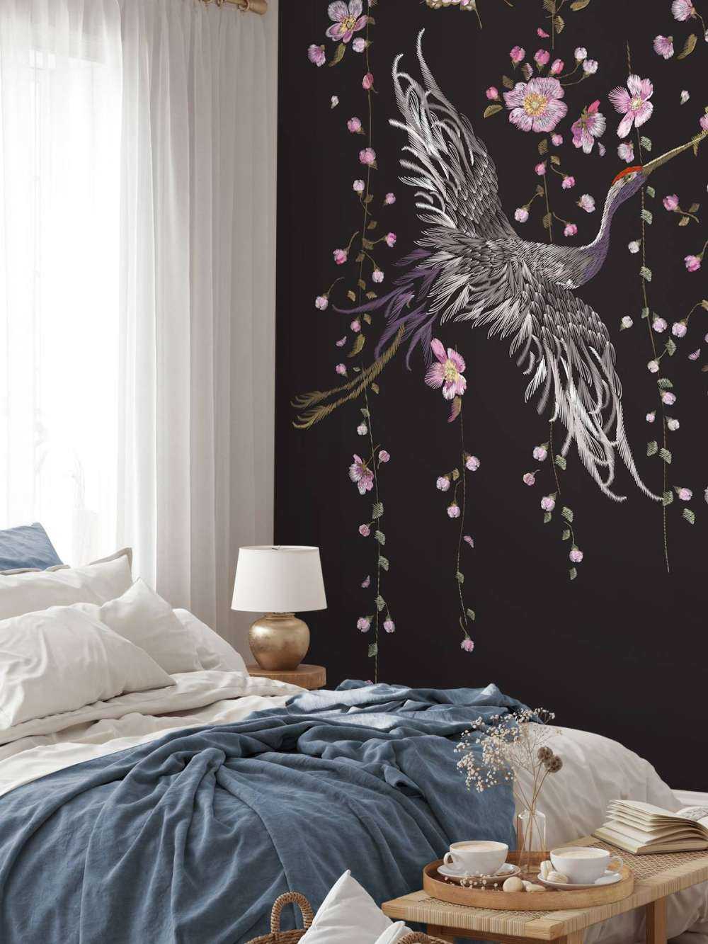 Kraanvogel bij roze bloemen