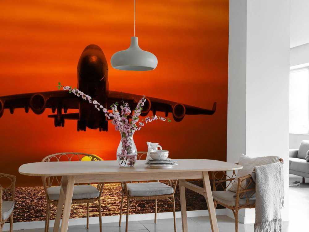 Passagiersvliegtuig boven de zee bij zonsondergang