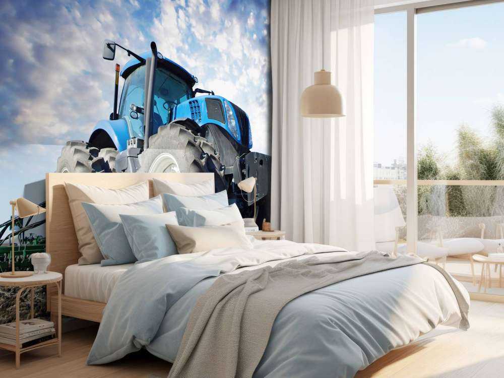 Grote blauwe tractor onder een bewolkte hemel