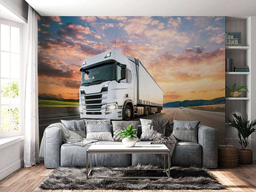 Witte vrachtwagen op de snelweg bij zonsondergang