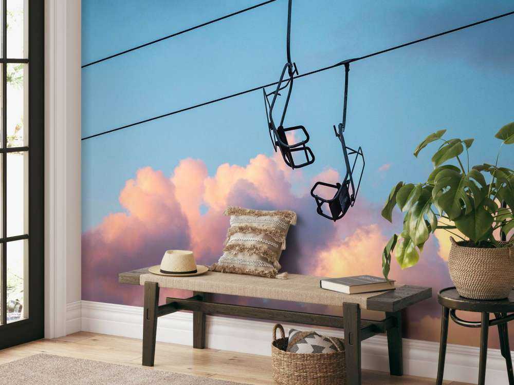 Stoeltjeslift boven roze avondwolken