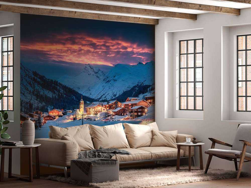 Avondlicht over bergdorp in de sneeuw