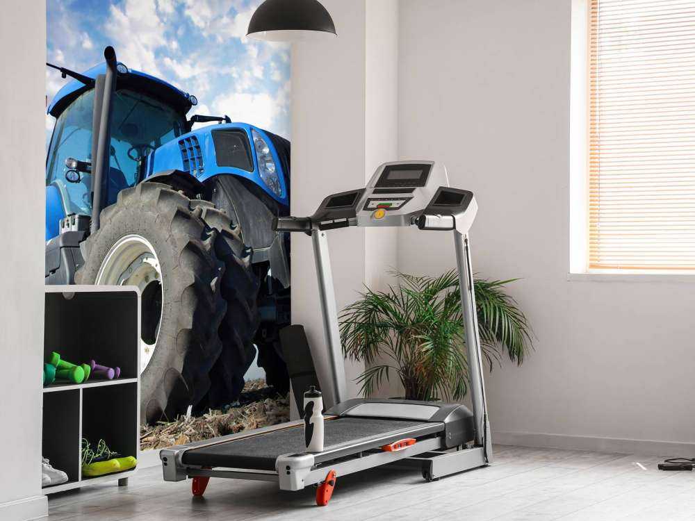 Grote blauwe tractor onder een bewolkte hemel