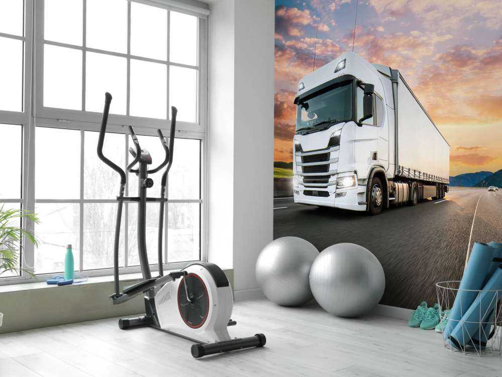 Witte vrachtwagen op de snelweg bij zonsondergang