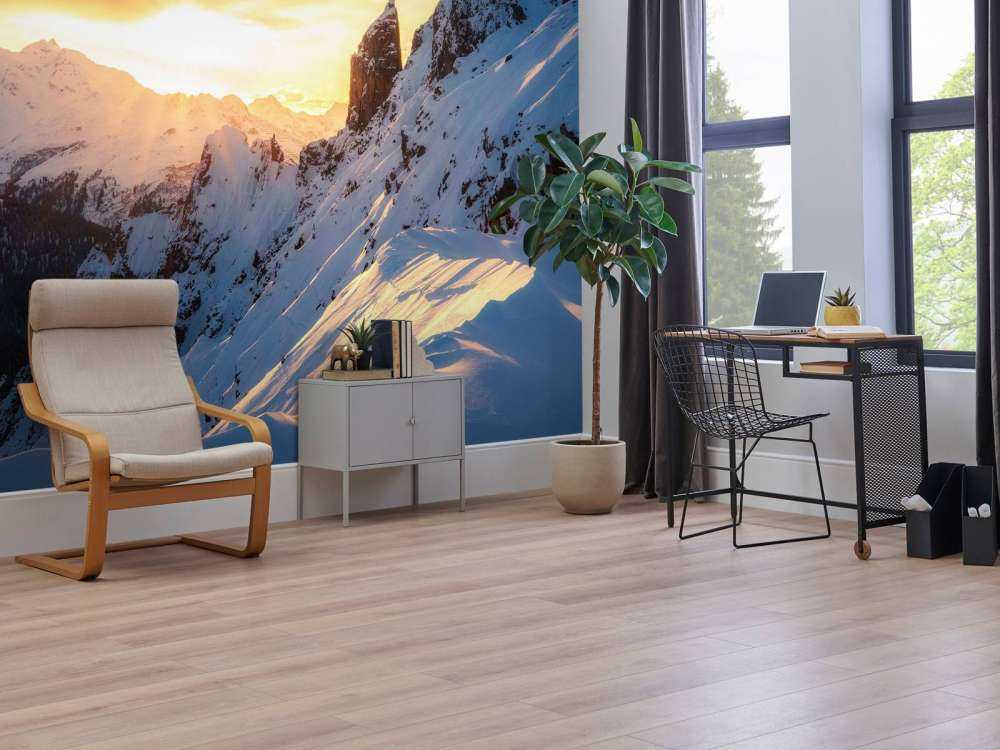 Avondzon achter besneeuwde bergtoppen