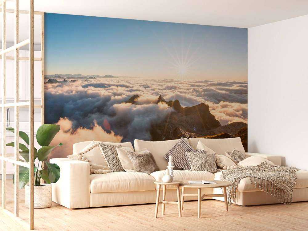 Zon boven wolkendek en bergtoppen