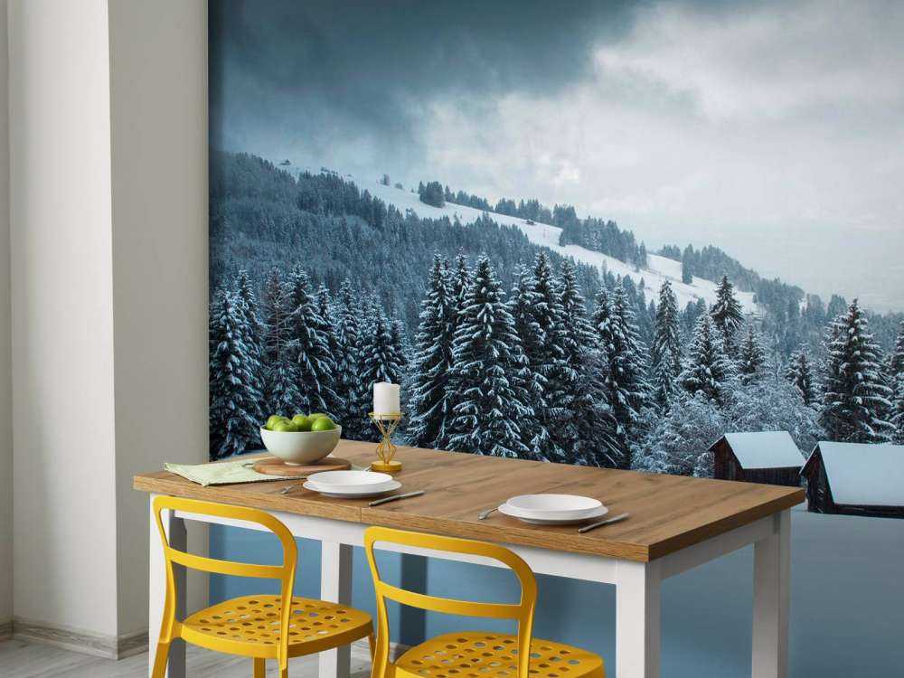 Besneeuwd dennenbos met houten hutten