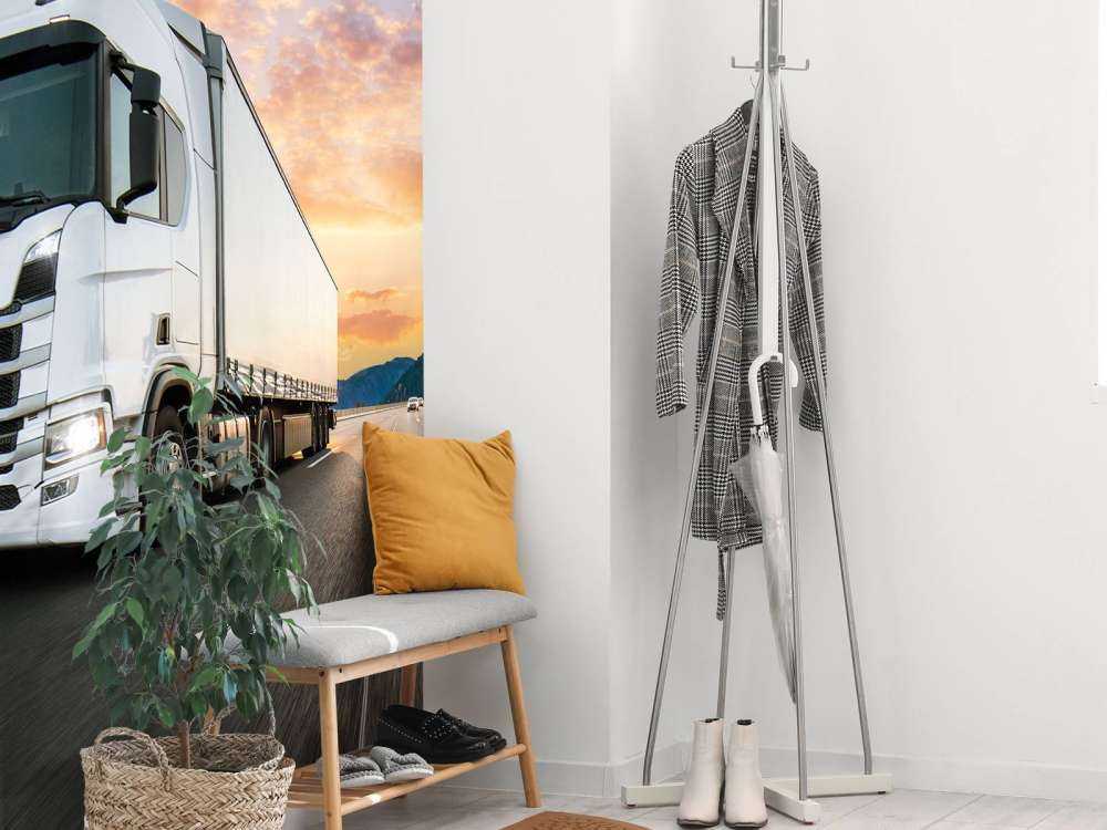 Witte vrachtwagen op de snelweg bij zonsondergang