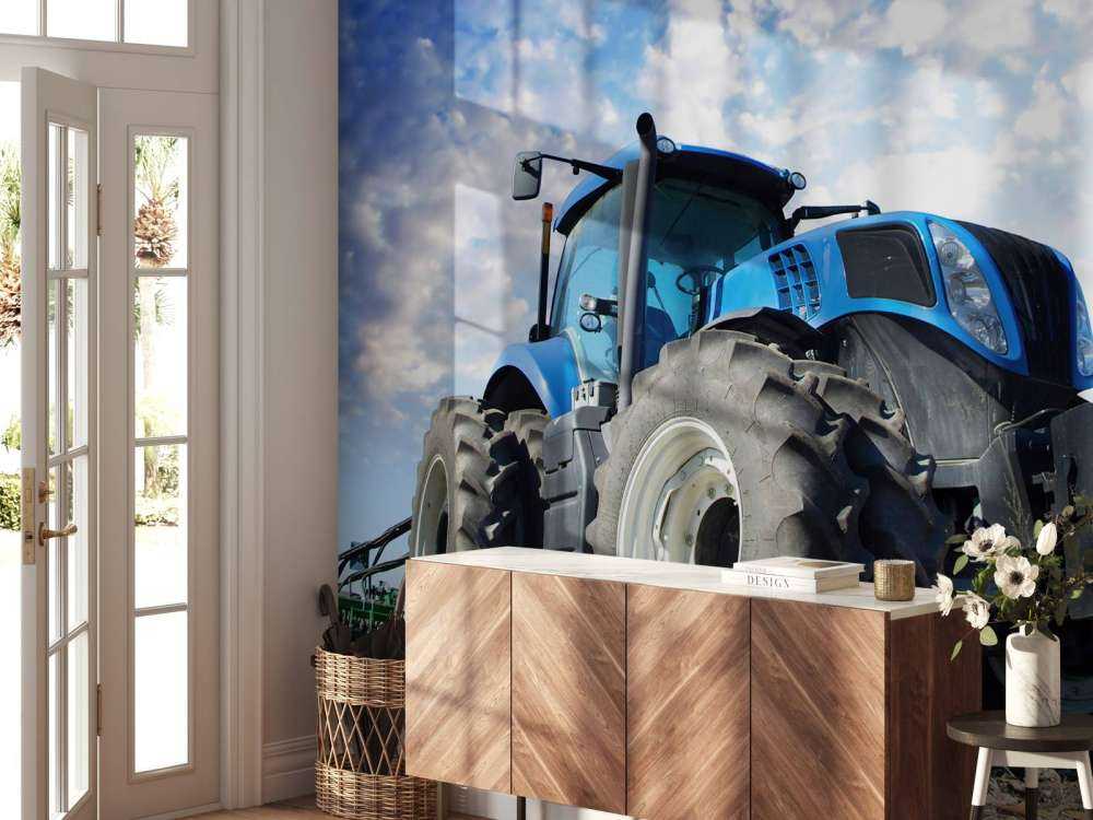 Grote blauwe tractor onder een bewolkte hemel