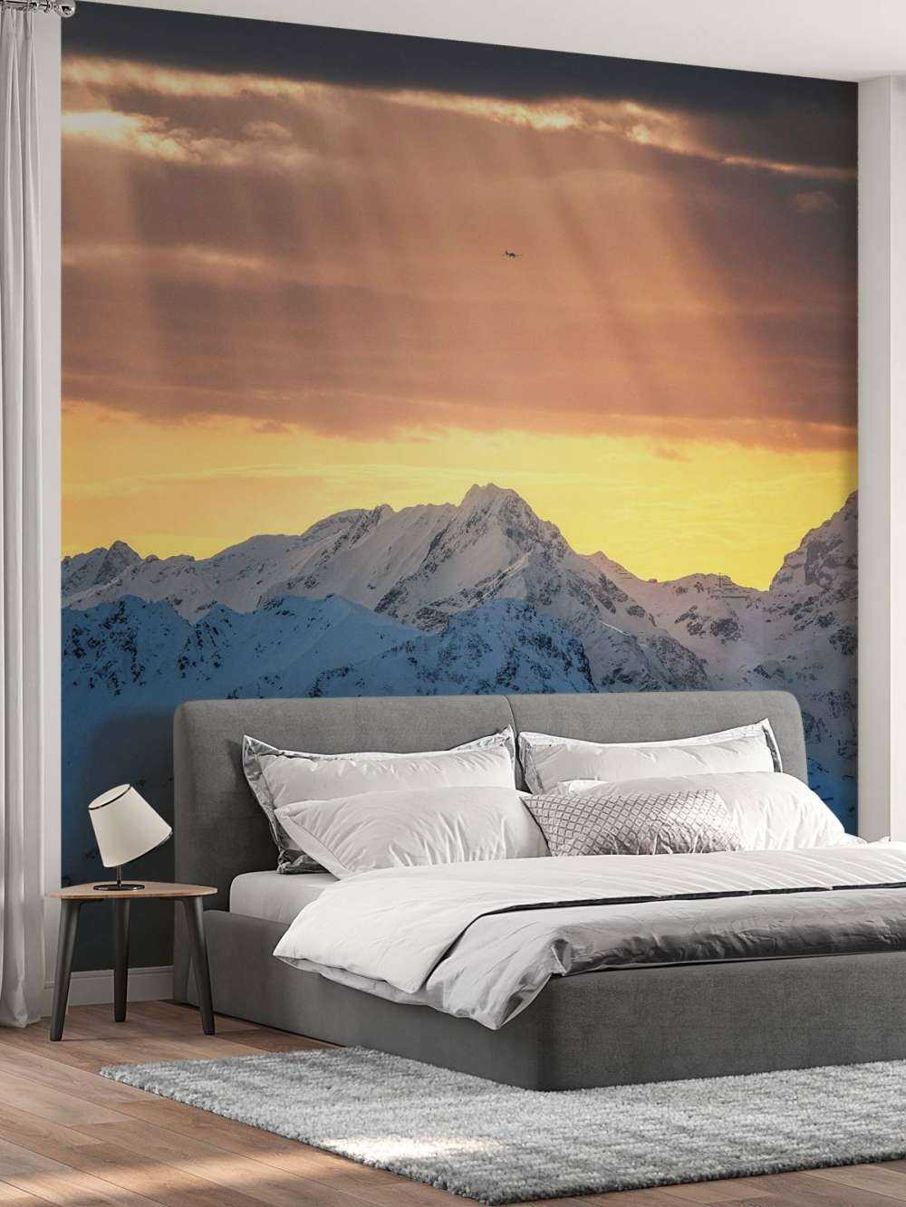 Zonnestralen boven besneeuwde bergtoppen