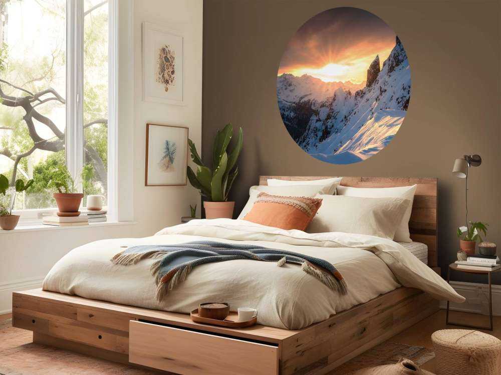 Avondzon achter besneeuwde bergtoppen