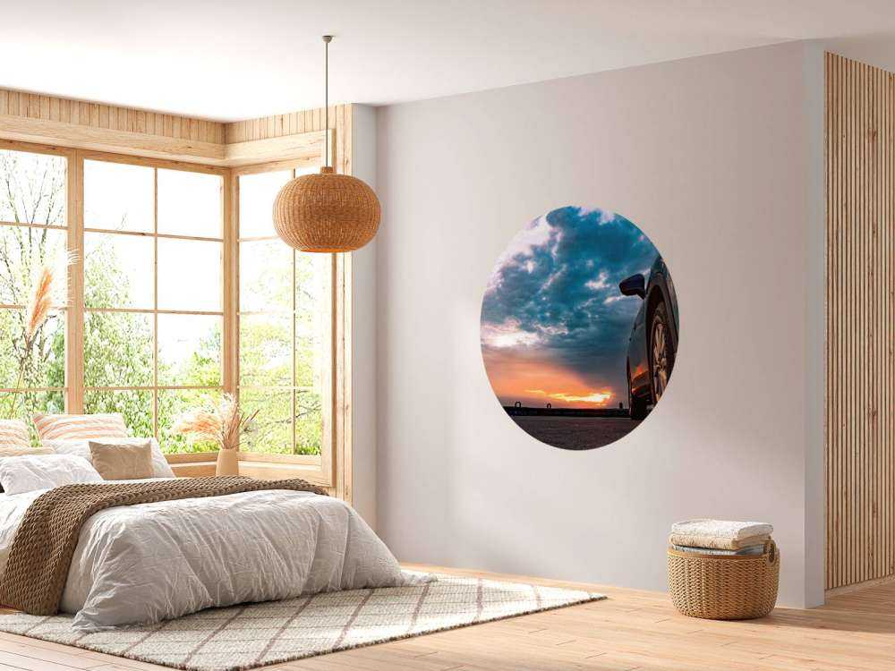 Een blauwe SUV met een unieke lucht op de achtergrond