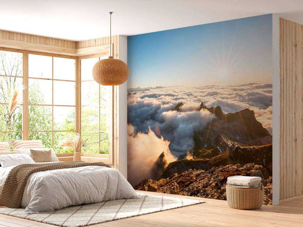 Zon boven wolkendek en bergtoppen