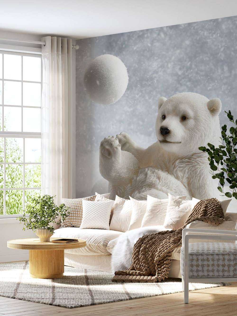 Een ijsbeer speelt met een sneeuwbal