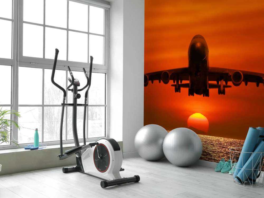 Passagiersvliegtuig boven de zee bij zonsondergang