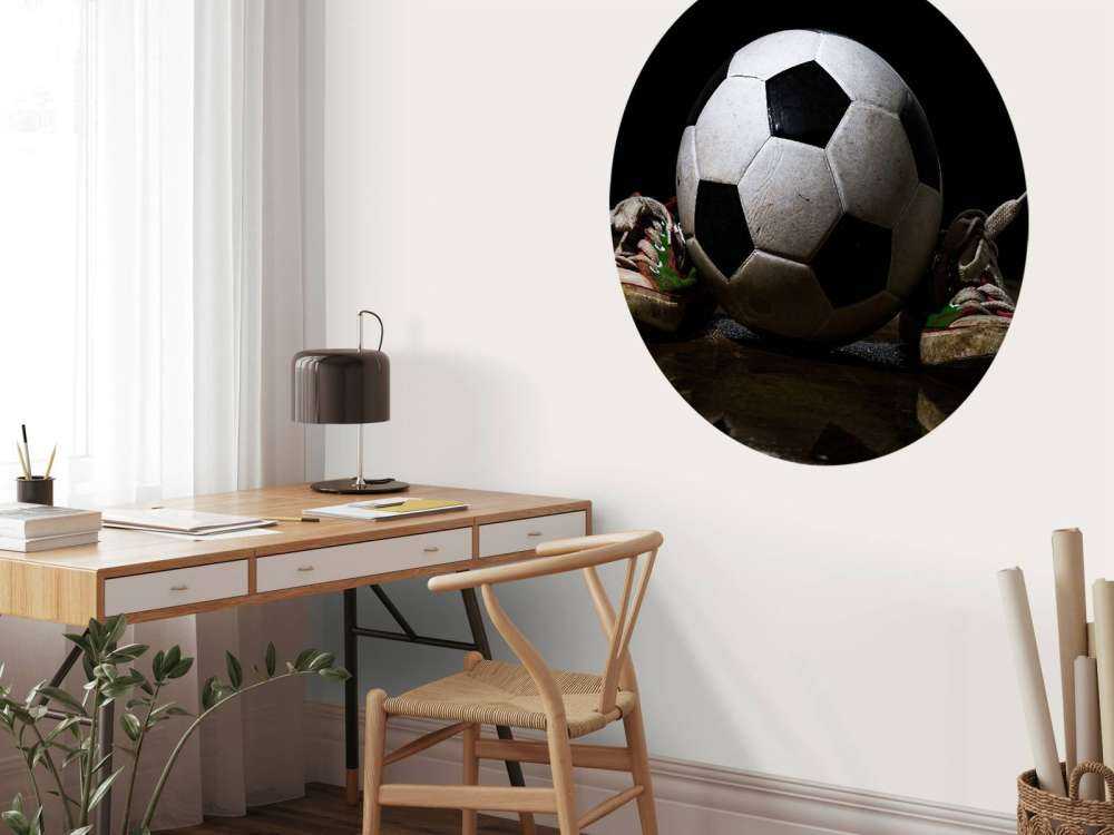 Voetbal tussen twee sneakers