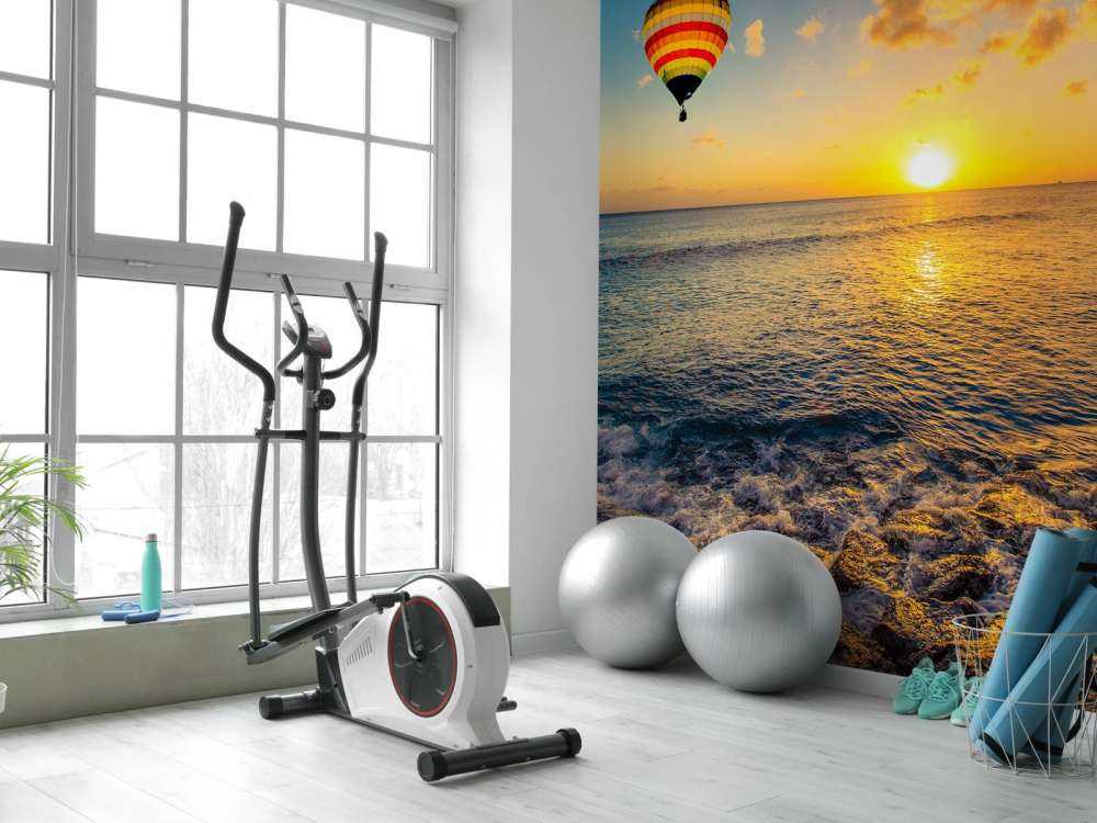 Luchtballon boven zee bij zonsondergang