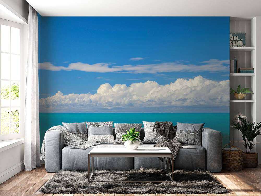 Panoramic view of a blue seascape with sailboat and cloudy sky