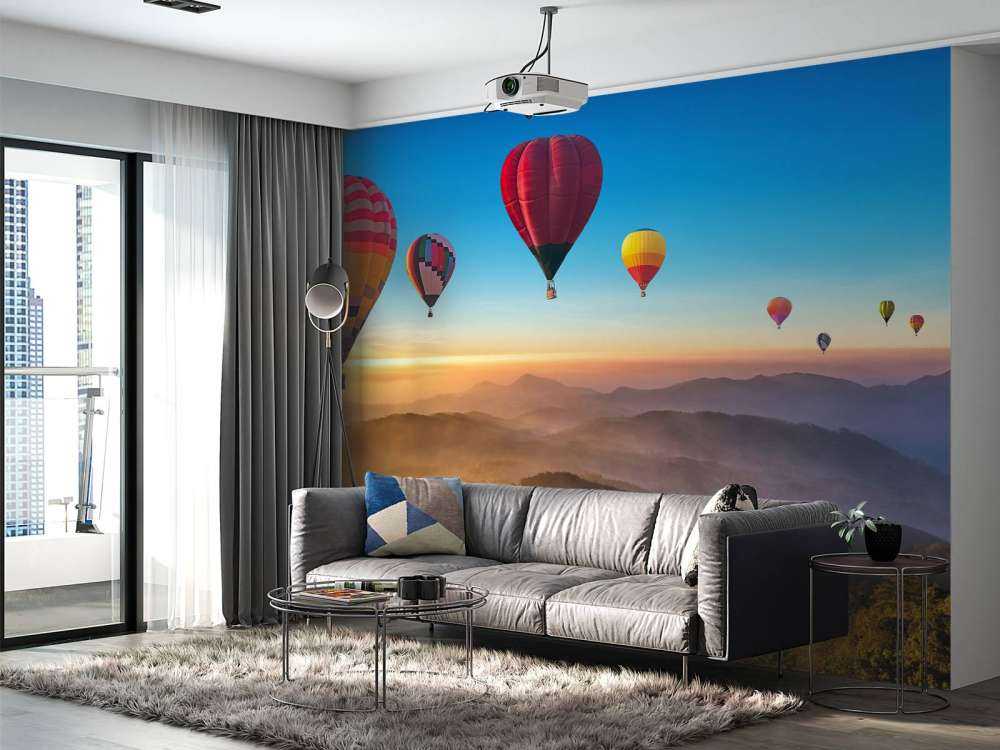 Grote groep luchtballonnen boven een mistig berglandschap