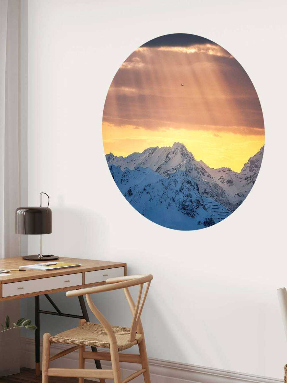 Zonnestralen boven besneeuwde bergtoppen