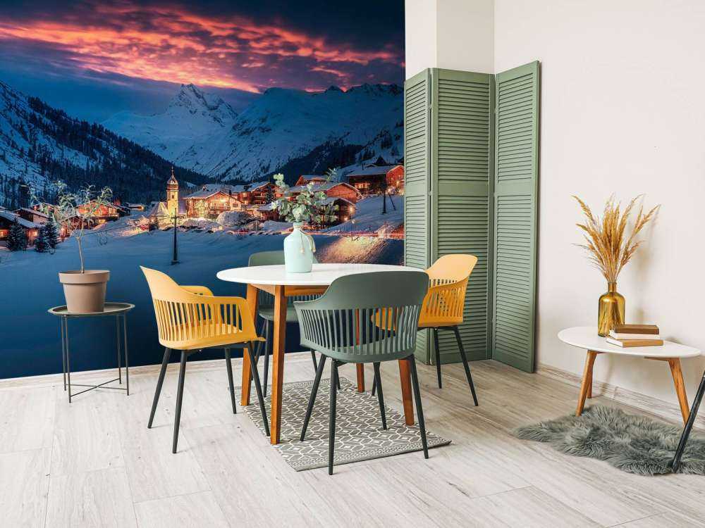 Avondlicht over bergdorp in de sneeuw