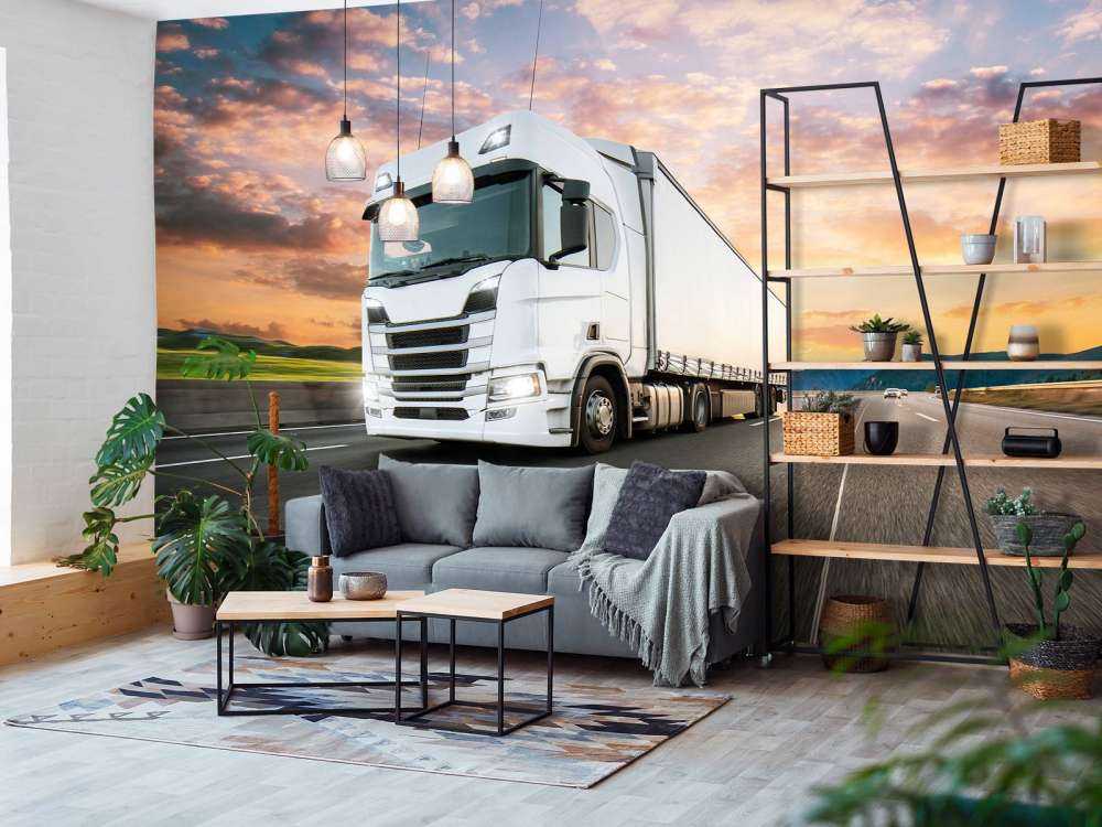 Witte vrachtwagen op de snelweg bij zonsondergang